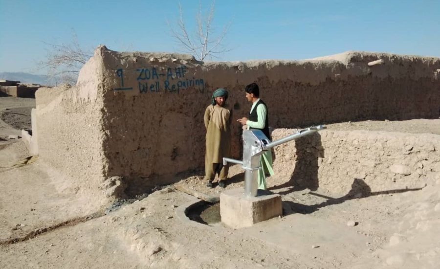 Zwei Männer vor einer neu installierten Wasserpumpe