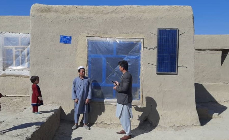 Männer stehen vor neugebautem Haus in Afghanistan