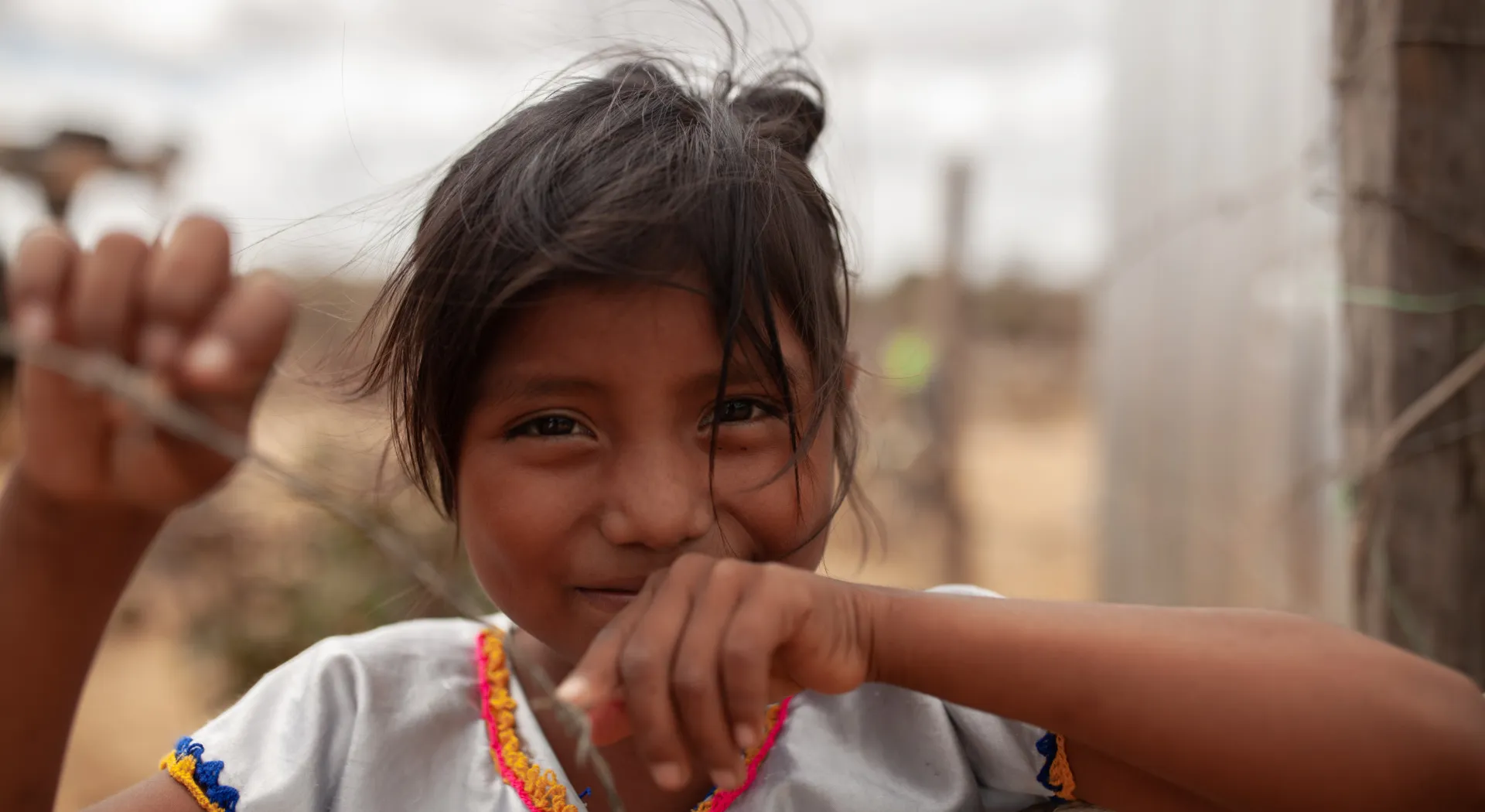 Bild zeigt Mädchen vor einem Stacheldraht in einem Flüchtlingscamp in Kolumbien