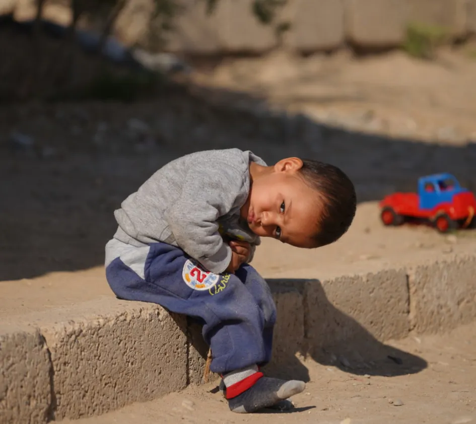 5 Fakten über Syrien: Ein Kind sitzt auf einer Bordsteinkante.
