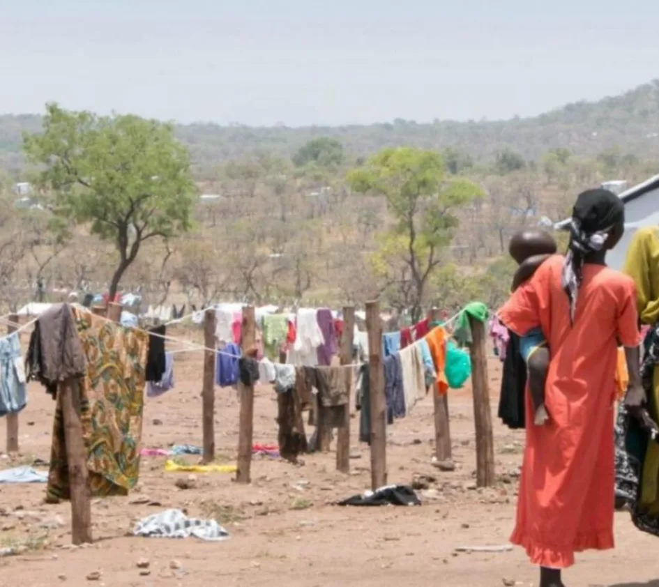 Die Geschichte Ugandas: Frauen mit Kind vor ihren Wäscheleinen