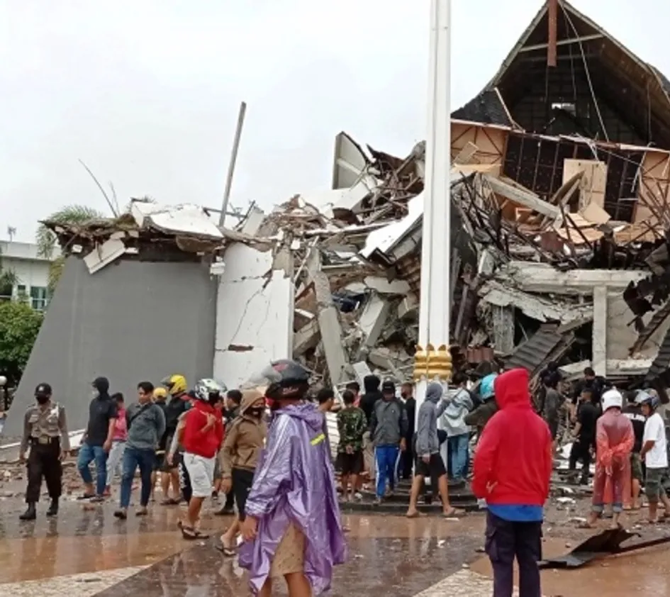 Erdbeben in Sulawesi: Menschen stehen vor zerstörten Häusern