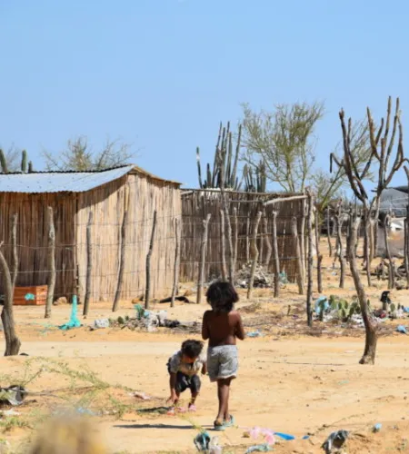 Was ist los in Kolumbien: Kinder laufen durch ein karges Flüchtlingscamp im Norden Kolumbiens