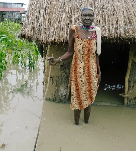 Hungersnot im Südsudan: Frau steht vor ihrem überschwämmten Haus