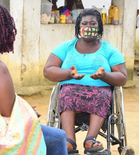 Frau im Rollstuhl erklärt etwas