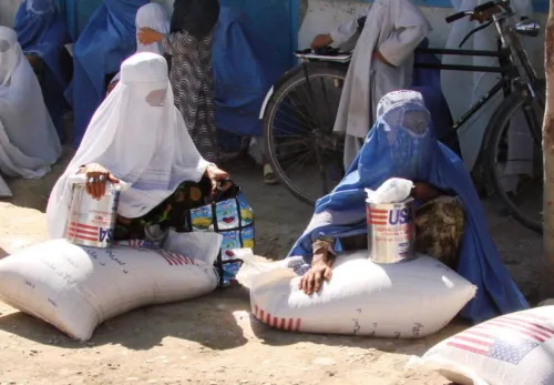 Taliban in Afghanistan: Eine Gruppe Frauen sitzt auf Nahrungsmittelsäcken