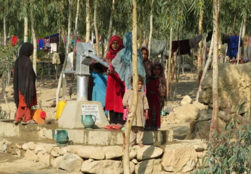 Frauen und Kinder bedienen eine Wasserpumpe in Nangarhar