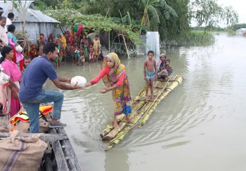 Sri Lanka: Frau auf einem Floß reicht Mann an Land Nahrung
