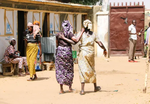 Das tut ZOA: Zwei Frauen in bunten Gewändern gehen Arm in Arm über die Straße
