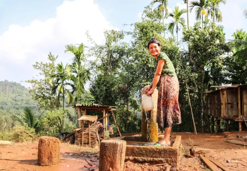 Myanmar: Frau schöpft Wasser an einer Wasserpumpe