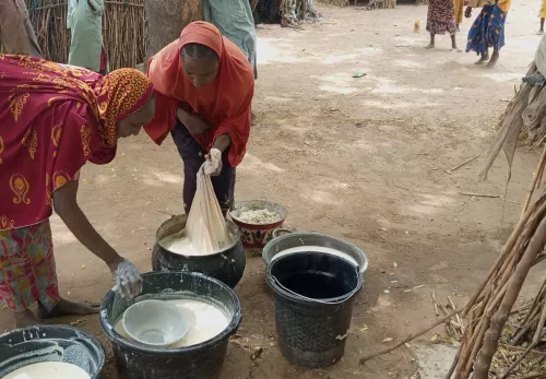 Mütter in Krisengebieten: Zwei Frauen waschen Wäsche in Wassereimern