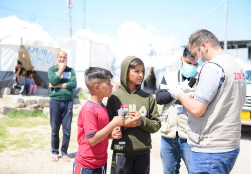 Klimagerechte Landwirtschaft im Irak: Kinder erhalten Lebensmittel von ZOA Mitarbeiter