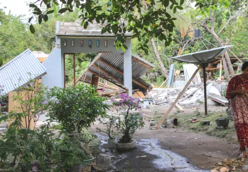 Frau in den Trümmern ihres Zuhauses