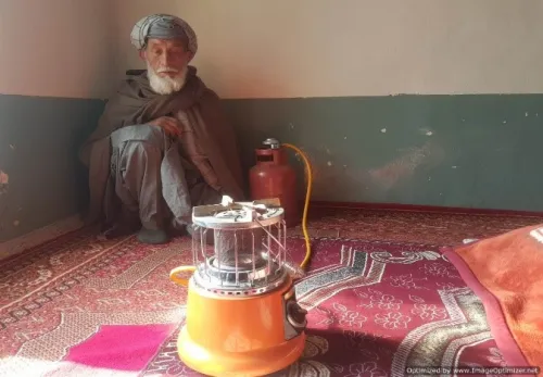 Durch den Winter: Afghanischer Mann sitzt vor einem Gaskocher