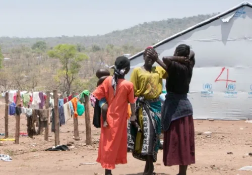Die Geschichte Ugandas: Frauen mit Kind vor Wäscheleinen