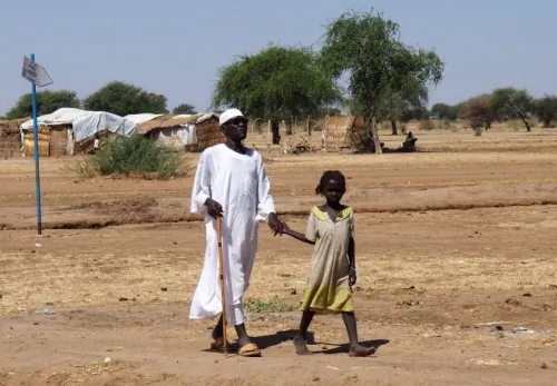 Armin mit einem Blindenstock an der Hand eines kleinen Mädchens
