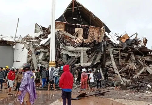 Erdbeben in Sulawesi: Menschen stehen vor zerstörten Häusern